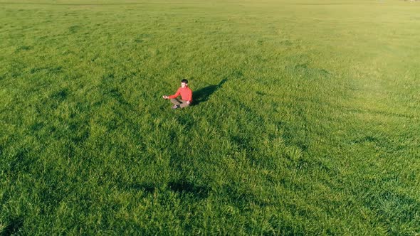 Low Altitude Radial Flight Over Sport Yoga Man at Perfect Green Grass. Sunset in Mountain