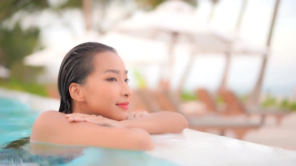 Young asian woman enjoy around outdoor swimming pool for leisure