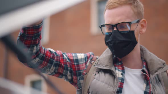 Man in Safety Mask Throwing Garbage in Bag Into Special Waste Bin