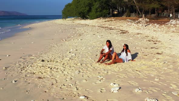 Women best friends on relaxing lagoon beach lifestyle by shallow sea and white sandy background of I