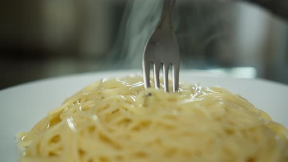 Woman Eating Pasta Plate with Hot Pasta Closeup Winds the Vermicelli on a Fork