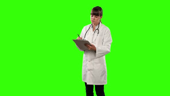 Side view of a female doctor checking some results with green screen