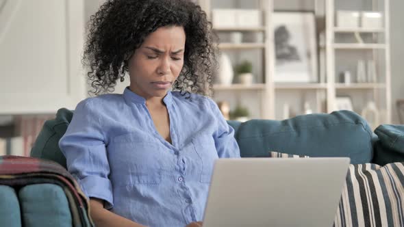 African Woman Frustrated By Loss Sitting on Couch