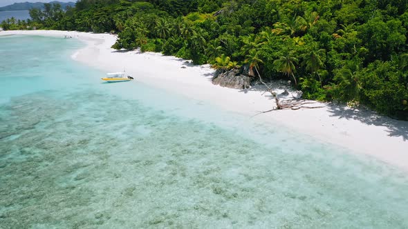 Aerial  Footage of Lonely Boat Moored on Perfect White Sand Exotic Beach with Turquoise Lagoon