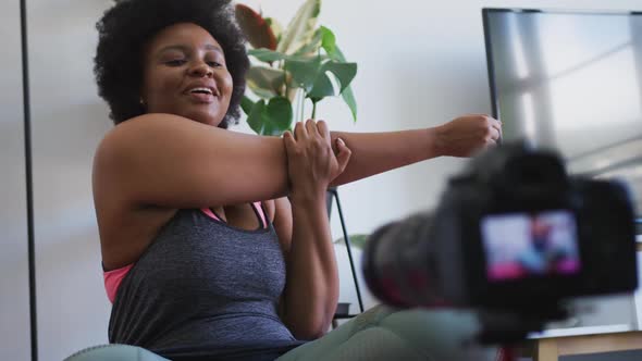 African american female plus size vlogger recording a video about working out