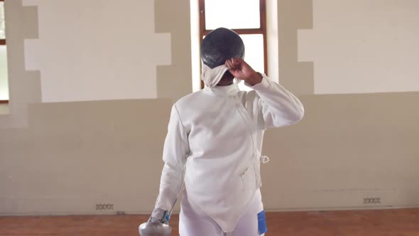 Female fencer athlete during a fencing training in a gym