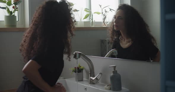 A woman staring at herself in the mirror