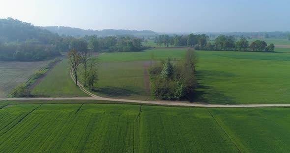 Moving Forward Over Green Fields and Gravel Paths in Summer Day