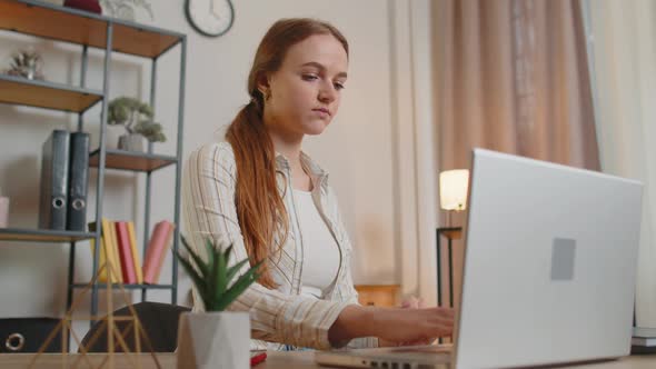 Young Woman Girl Using Laptop Computer Sitting at Table Working Typing on Keyboard From Home Office