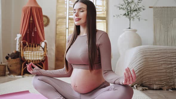 Pregnant Woman Meditates Breathing Slowly in Lotus Pose