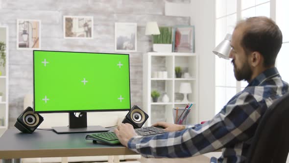 Man Working on Green Screen PC in Bright Room