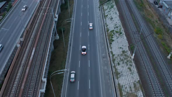 Aerial drone shot of a car driving on a bridge.