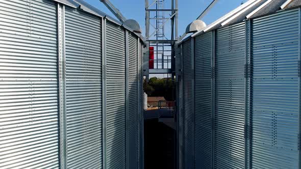 Silver grain elevators outdoors. Exterior of modern aluminum containers for storing harvest.