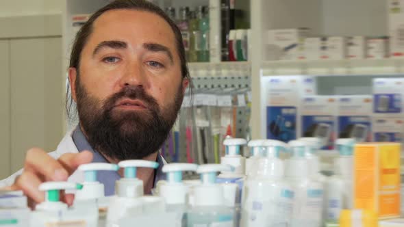 Bearded Pharmacist Smiling To the Camera, While Working at Drugstore