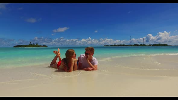Man and lady suntan on idyllic shore beach trip by blue ocean with white sandy background of the Mal