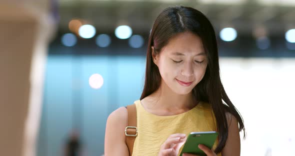 Woman use of mobile phone in the city at night