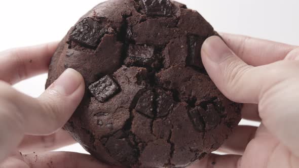 Double Chocolate Fudge Cookie Split By A Person's Hand. - Close Up, Slow Motion