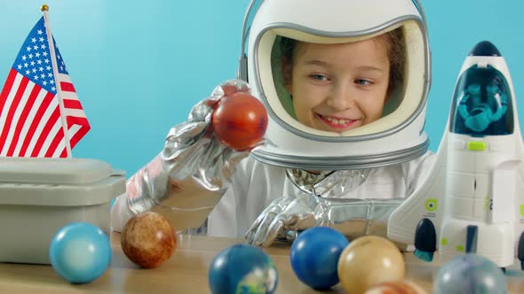 Smiling Child Holding a Red Planet Mars Space Rocket in His Hands Closeup Pilot Traveling Into Space