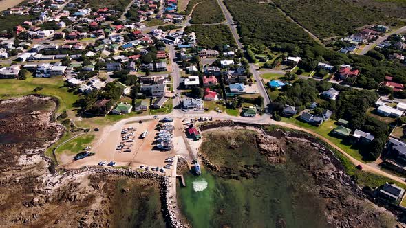 Aerial tilt-down over harbour as shark cage diving boat is pulled up slipway
