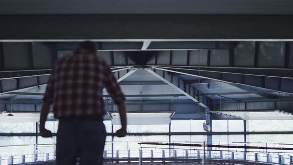 Agricultural Farmer Inspecting Cowshed with Modern Automated Milking Device