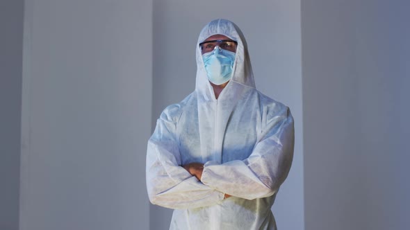 Caucasian male medical worker wearing protective clothing with mask and safety glasses