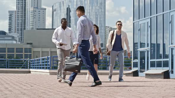 Coworkers Walking Outdoors and Discussing Business