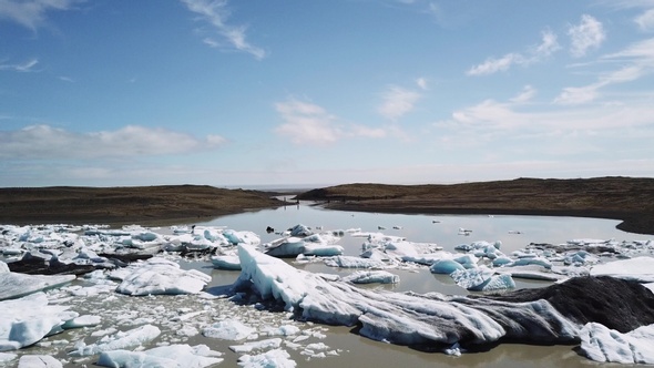 Aerial drone flight over Glacier Lagoon with icebergs.