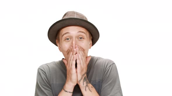 Surprised Young Handsome Man in Hat Smiling Rejoicing Over White Background