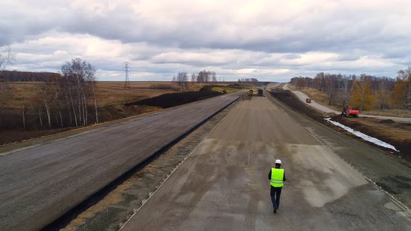 Worker in a Helmet, is on the Construction of the Road