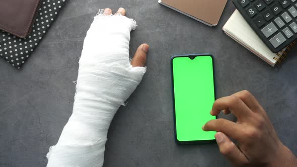 Injured Painful Hand with Bandage and Using Smart Phone