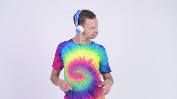 Studio Shot of Happy Man Wearing Tie-dye Shirt and Listening To Music