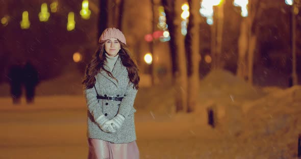 Beautiful Girl Walks on the Night Street in Winter