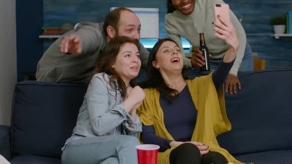 Group of Mixed Race People Taking Pictures with Phone While Sitting on Couch