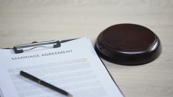 Marriage Agreement on Table, Gavel Striking on Sound Block, Marital Contract