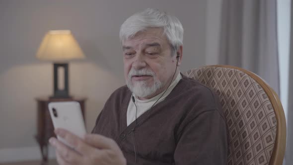 Portrait of Confident Old Caucasian Man Talking at Selfie Camera. Senior Retiree Having Video Call