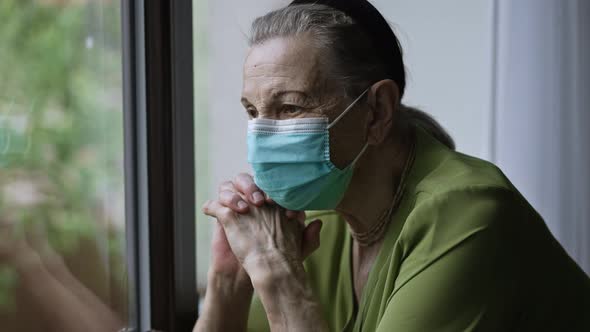 Senior Woman in Face Mask Near the Window