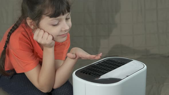 Child clean the air with purifier. 