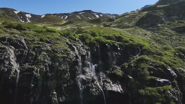 Water Flows Down the Slope of a Mountain Drops Splash From a Huge Rock