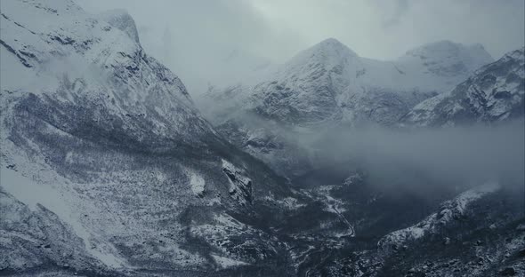 Winter Aerial shot of majestic mountains covered by fog in Olden, Norway