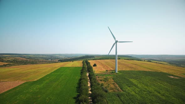 Aerial drone view of working wind turbine in Moldova. Wide fields around it