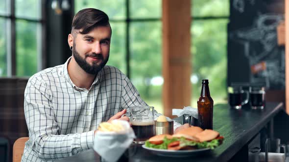 Pleasant European Stylish Guy Relaxing at Pub Restaurant Posing Looking at Camera Medium Shot