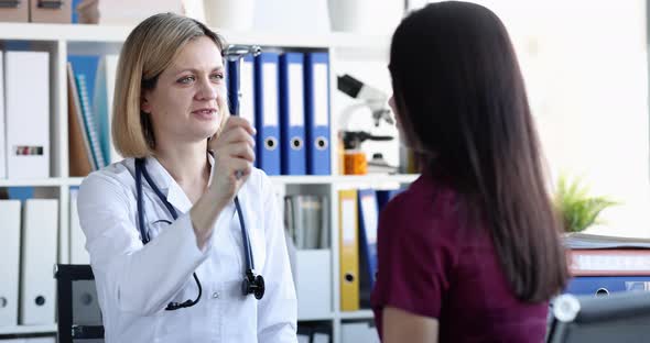 Neurologist Checks Nerve Reflexes with Hammer of Patient Eyes