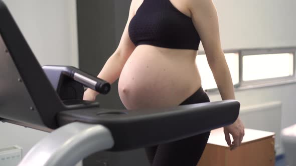 Pregnant Woman Training Treadmill Machine in Gym Cardio Exercises on Running Simulator