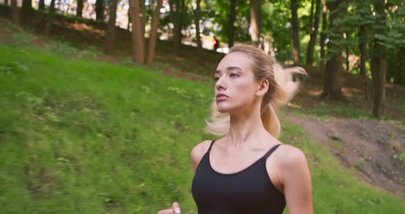 Motivated Young Female Runner Training in Park