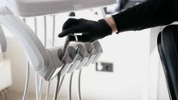 Closeup of a Male Dentist in Gloves Takes Tools Vacuum Equipment in the Dental Office Closeup