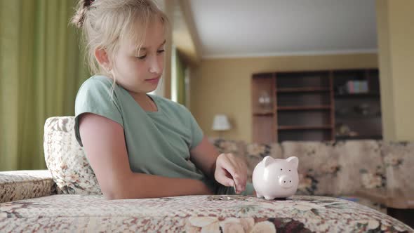 Girl Putting Coin in Piggy Bank Saving Money Concept