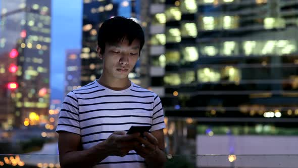 Man using mobile phone in city at night 