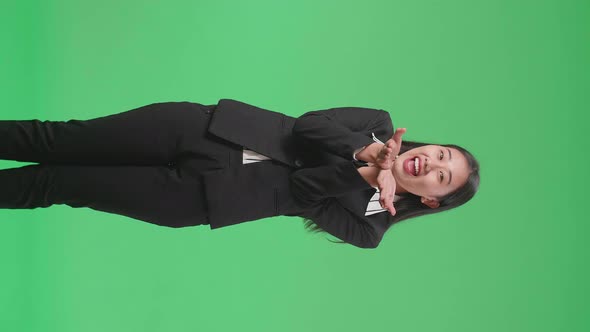 An Asian Business Woman Blowing Kisses And Smiling To Camera In The Green Screen Studio