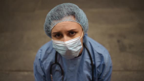 Dolly Out Tired Female Nurse or Doctor Sits Near Hospital and Lowers Head