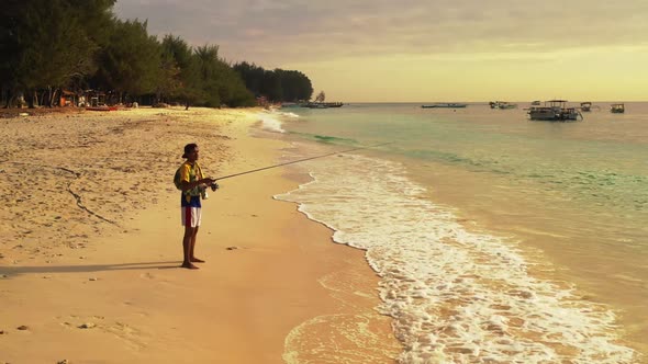 One man fisherman on paradise resort beach vacation by transparent lagoon and white sand background 